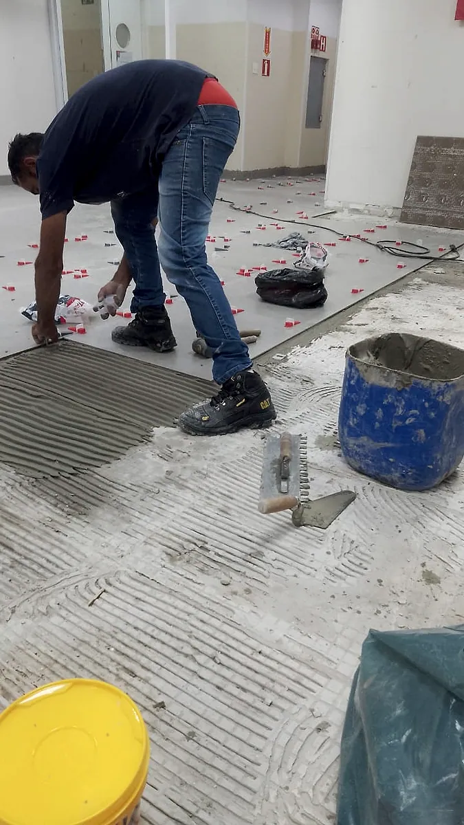Profissional realizando assentamento de porcelanato